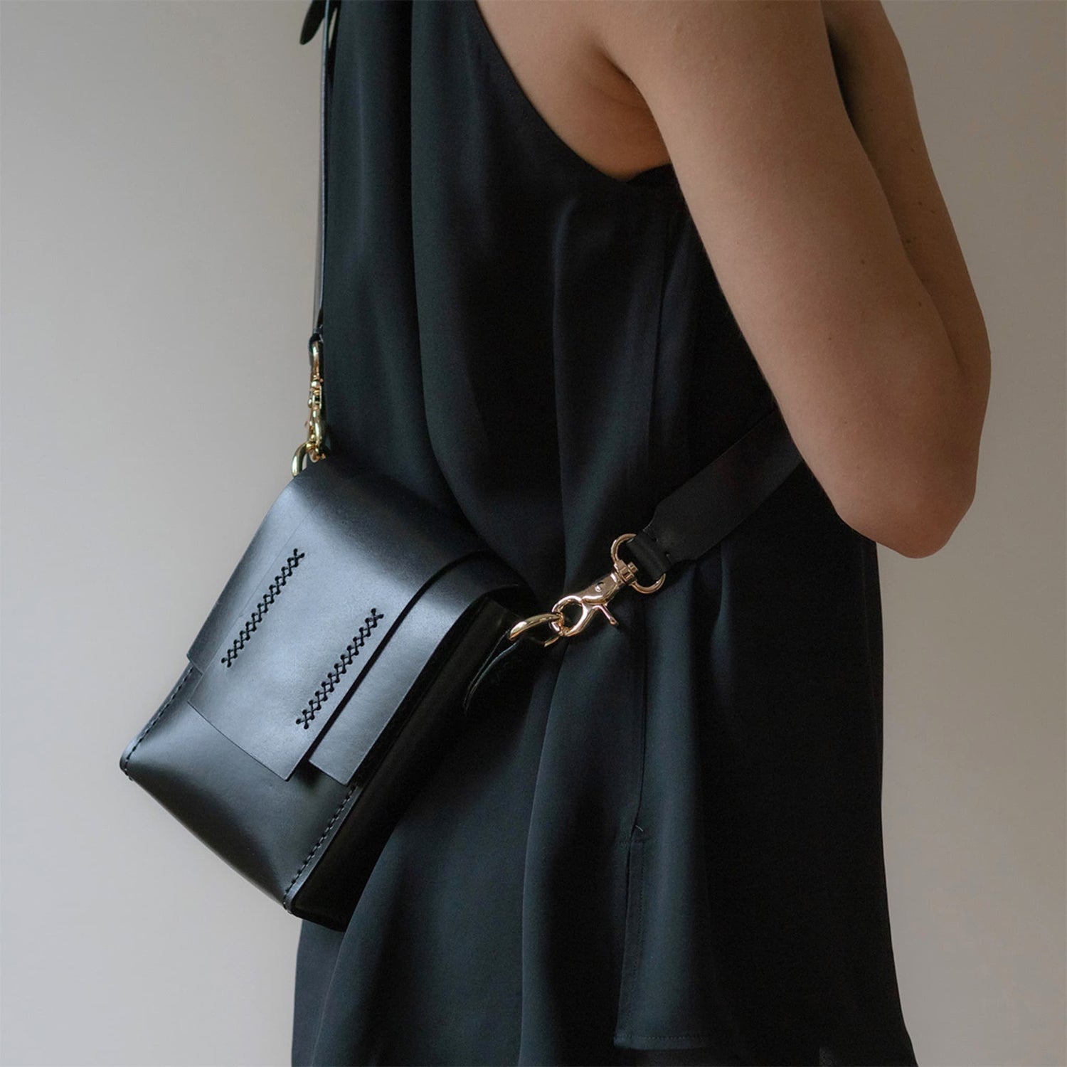 Petit sac bandoulière en cuir noir Mozza porté sur robe noire